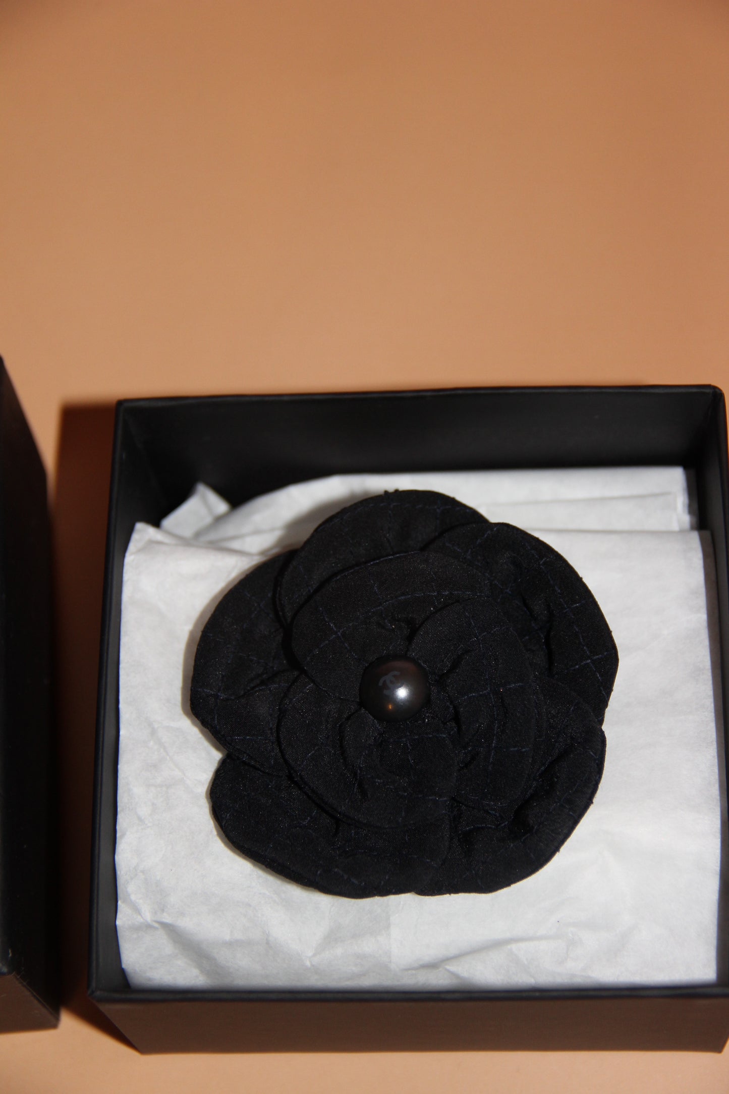 Broche Chanel camélia noire en tissu avec perle